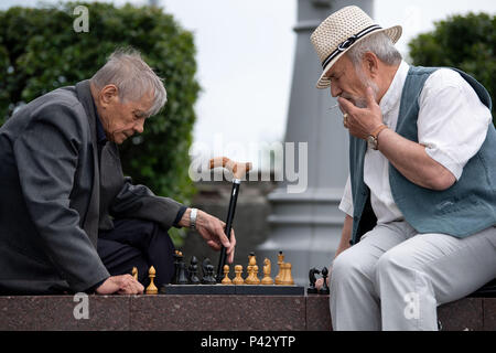 Yekaterinburg, Russia. 20th June, 2018. Soccer, World Cup 2018: Two men are playing chess on a street corner. Credit: Marius Becker/dpa/Alamy Live News Stock Photo