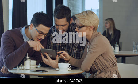 Creative team using smartphone and talking in casual office Stock Photo