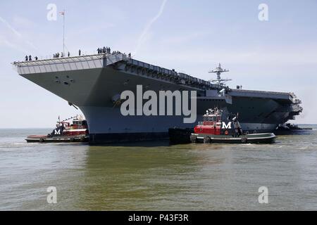 The Pre-Commissioning Unit Gerald R. Ford (CVN 78) is guided by tug boats back to pier side in the James River at Newport News Shipbuilding during the turn ship evolution. This operation ensures safe maneuvering, evaluates propulsion and steering systems, and tests operational procedures. CVN 78, the first in its class, is equipped with nuclear propulsion, advanced radar, electromagnetic aircraft launch systems, and reinforced flight decks, marking a critical milestone in carrier construction and readiness prior to commissioning. Stock Photo