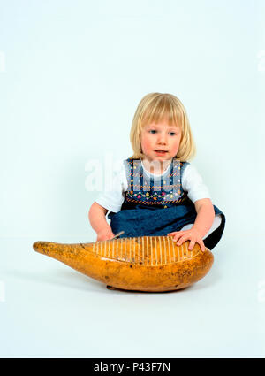 Child playing a Guiro Stock Photo