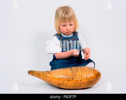 Child playing a Guiro Stock Photo