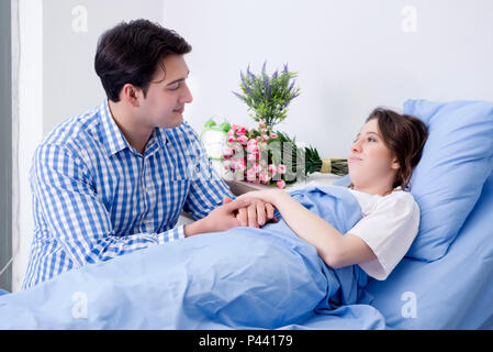 Caring loving husband visiting pregnant wife in hospital Stock Photo