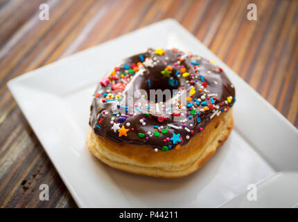 A chocolate donut with sprinkles from Picnic Too, a popular cafe and restaurant in Victoria, British Columbia, Canada. Stock Photo