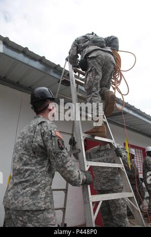 U.S. Army Soldiers assigned to 1020th and 1022nd Engineering Battalion, Arizona National Guard, carry equipment up to the roof of a clinic in La Blanca, Guatemala, June 6, 2016. Task Force Red Wolf and Army South conducts Humanitarian Civil Assistance Training to include tactical level construction projects and Medical Readiness Training Exercises providing medical access and building schools in Guatemala with the Guatemalan Government and non-government agencies from 05MAR16 to 18JUN16 in order to improve the mission readiness of US Forces and to provide a lasting benefit to the people of Gua Stock Photo