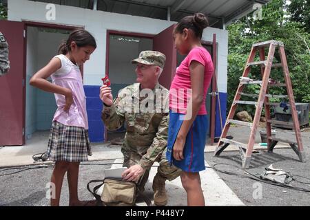 U.S. Army Brig. Gen. Keith Klemmer The Arkansas deputy adjutant general, greets Guatemalan children with candy at the Catarina construction site, Guatemala, June 8, 2016. Task Force Red Wolf and Army South conducts Humanitarian Civil Assistance Training to include tactical level construction projects and Medical Readiness Training Exercises providing medical access and building schools in Guatemala with the Guatemalan Government and non-government agencies from 05MAR16 to 18JUN16 in order to improve the mission readiness of US forces and to provide a lasting benefit to the people of Guatemala. Stock Photo