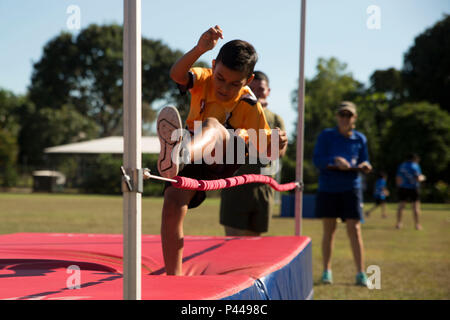 Lance Cpl. Juan G. Santos watches a student high jump during a sports day event at Alawa Primary School, Northern Territory, Australia, on June 10, 2016. U.S. Marines volunteer at the school as part of the School Mentorship Program. The program allows Marines to engage with and contribute to the local community during their six-month deployment in Darwin, Australia. Santos, from San Antonio, Texas, is a rifleman with 1st Battalion, 1st Marine Regiment, Marine Rotational Force – Darwin. (U.S. Marine Corps photo by Cpl. Mandaline Hatch/Released) Stock Photo