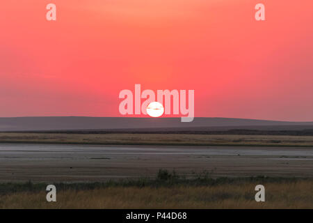 Beautiful orange sunrise under salt lake in Crimea Republic, Russia Stock Photo
