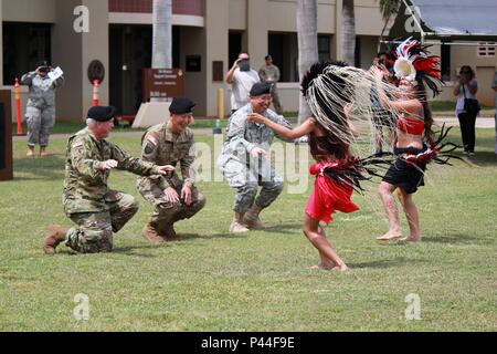 From left: Col. Timothy Clemente, 322nd Civil Affairs Brigade incoming commander, Brig. Gen. Stephen Curda, commanding general for the 9th Mission Support Command, and Col. Joseph Trinidad, 322nd Civil Affairs Brigade outgoing commander, join in on a traditional Tahitian dance before the closing of the relinquishment of command ceremony on June 26 at the Daniel K. Inouye Complex parade field. (Photo by U.S. Army Staff Sgt. Deziree I. Lau, 305th Mobile Public Affairs Detachment, 9th Mission Support Command) Stock Photo