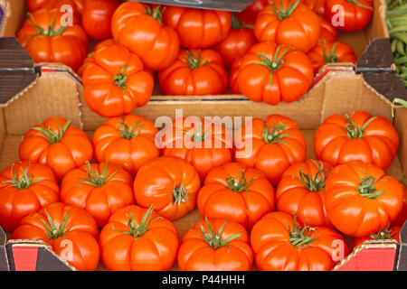 Big tomatoes in crates at market Stock Photo