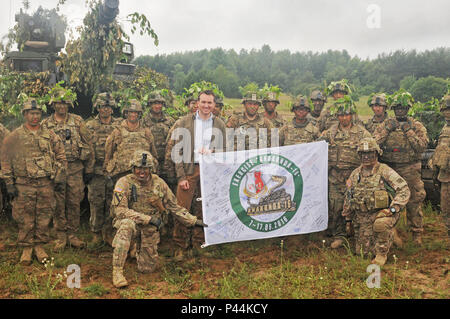 Secretary of the Army, Hon. Eric Fanning holds an Exercise Anaconda 2016 flag while visitng US troops participating in the exercise in Drawsko Pomorskie, Poland.  a Polish-led, multinational exercise running from June 7-17, involves approximately 31,000 participants from more than 20 nations and is a premier training event for U.S. Army Europe. Stock Photo