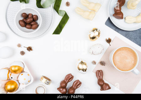 Happy Easter. Stylish stationery background with chocolate eggs. gold and white eggs and accessories on white background. Table decorating for holiday Stock Photo