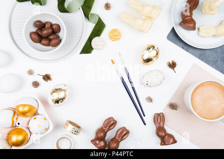 Happy Easter. Stylish stationery background with chocolate eggs. gold and white eggs and accessories on white background. Table decorating for holiday Stock Photo