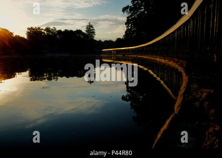 Rail and reflection along the lakeshore at Pullen Park in downtown Raleigh North Carolina Stock Photo