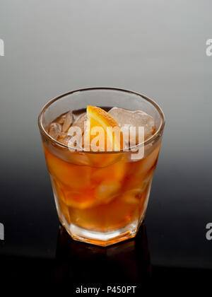 Closeup glass of negroni cocktail decorated with citrus on dark background. Stock Photo