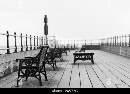 Benches aligned in a row at the seaside pier. Stock Photo