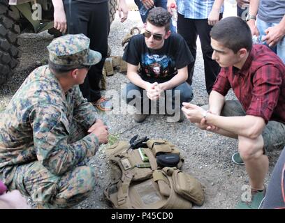 Sgt. Brandon Derenoff, Artillery Radio Chief with the Black Sea Rotational Force, Combined Arms Company, speaks to teenagers from local high schools about the personal protective gear U.S. soldiers wear at the Bulgarian Military Police Regional Department in Sliven, Bulgaria, June, 1, 2016. The teenagers were curious about the differences between U.S. armed forces and Bulgarian armed forces. This display event gave the local community the chance to witness the partnership between the U.S. and Bulgarian forces. (U.S. Army photo by Spc. Staci Evbuomwan, 194th Engineer Brigade, Tennessee Army Nat Stock Photo