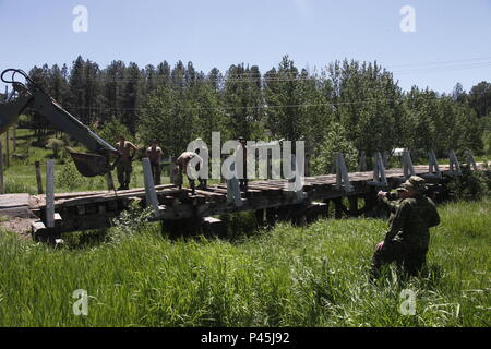 Col. John Conrad commander of the 41st Canadian Brigade Group, observes Canadian soldiers of the, 5e Régiment du génie de combat, conducting a bridge restoration operation on a civilian footbridge in Custer S.D. during Golden Coyote, June 15, 2016. The Golden Coyote exercise is a three-phase, scenario-driven exercise conducted in the Black Hills of South Dakota and Wyoming, which enables commanders to focus on mission essential task requirements, warrior tasks and battle drills. (U.S. Army photo by Spc. Mitchell Murphy/Not Released) Stock Photo