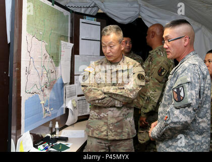 Brig. Gen. Stephen K. Curda (left), Commander, 9th Mission Support Command, speaks with Maj. Paul Han, executive officer, 63rd Brigade Support Battalion, during a visit to the Army Logistics Operations Center at exercise Imua Dawn 2016, Sagamihara, Japan, June 18, 2016.  Imua Dawn 2016 focuses on maneuver support operations and enhancing cooperative capabilities in mobility, Humanitarian Assistance and Disaster Relief (HADR), Noncombatant Evacuation Operations (NEO), and sustainment support in the event of natural disasters and other crises that threaten public safety and health in the Pacific Stock Photo