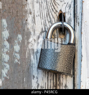 Small lock on an old wooden door Stock Photo