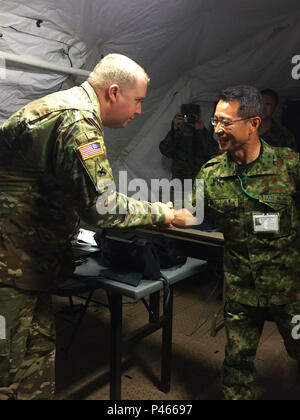 Maj. Gen. Mitsuhiko Horikiri (right), vice chief of staff (international), Japan Ground Self-Defense Force Central Readiness Force, shake hands with Cpt. Thomas N. Hacker, future plans and operations officer, 303rd Maneuver Enhancement Brigade, during a visit to Sagamihara Depot Mission Training Complex during exercise Imua Dawn 2016, Sagamihara, Japan, June 18, 2016. Imua Dawn 2016 provides opportunities for U.S. and the Japan Ground Self-Defense Force to come together and train for potential real world events. Humanitarian Assistance and Disaster Relief (HADR) and Noncombatant Evacuation Ope Stock Photo