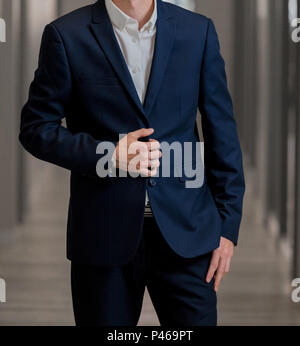 Cropped head Man standing in a smart suit with one hand on jacket button Stock Photo