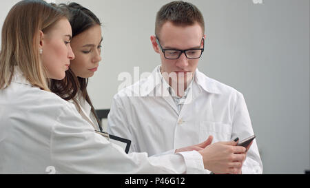 Female doctor showing something on tablet to her medical team Stock Photo