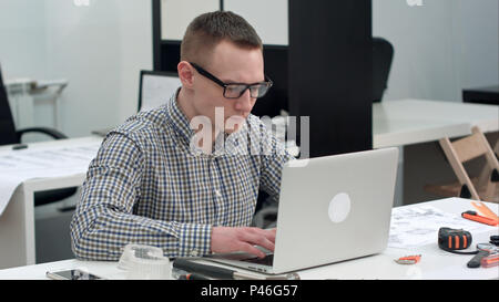 Concentrated architect designing new project on laptop Stock Photo