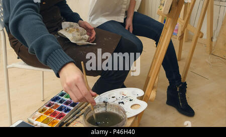 Art teacher and her apprentice working on a watercolor picture Stock Photo