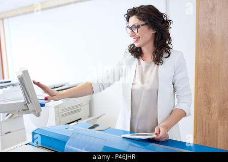 Cheerful woman setting printer Stock Photo