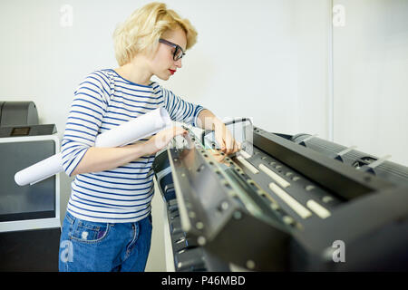 Woman with roll of paper checking printer Stock Photo