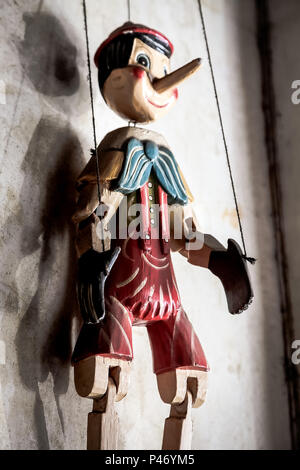 Selective Focus Abstract image of a Wooden String Puppet Boy hanging on a wall Stock Photo