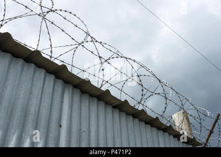 Tall barbed wire security fence Stock Photo
