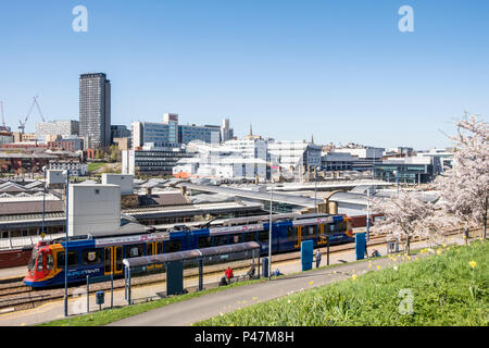 The Supertram at Sheffield Station tram stop with the city of Sheffield skyline in the background, Sheffield, South Yorkshire, England, UK Stock Photo