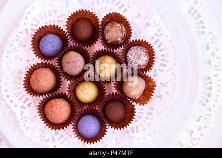 A set of color truffle candy on a white plate with lace. Stock Photo