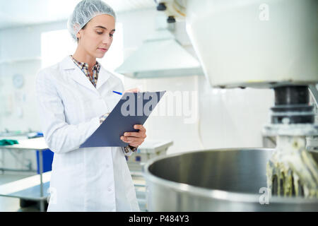 Confectionery factory worker taking notes Stock Photo