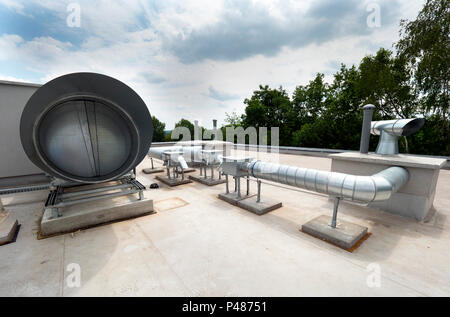 Elements of ventilation and air conditioning placed on the roof of a block of flats Stock Photo