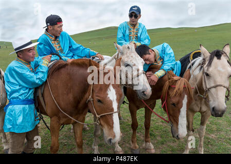 Young horsemen hang out with horses at Zhenglanqi Wuyi Farm, Inner Mongolia, China Stock Photo