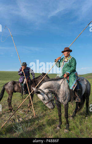 Horseman dressed in traditional costume hold rope and pole urga or lassoe, Xiwuzhumuginqi, Inner Mongolia, China Stock Photo