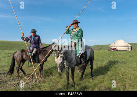 Horseman dressed in traditional costume hold rope and pole urga or lassoe, Inner Mongolia, China Stock Photo