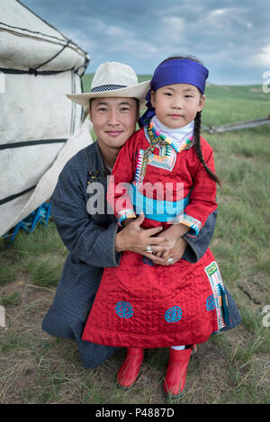 Mongolian father embraces his young daughter at their summertime camp, Xiwuzhumuginqi, Inner Mongolia, China Stock Photo