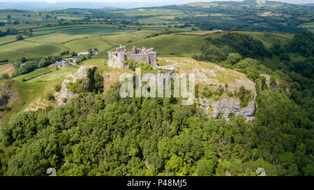 Aerial view of sunlight illuminating the ruins of an ancient castle on a large limestop cliff Stock Photo