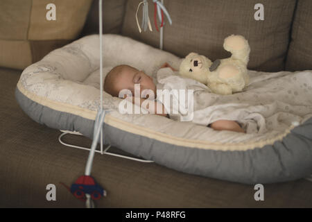 Cute little baby sleeping in the crib on sofa Stock Photo