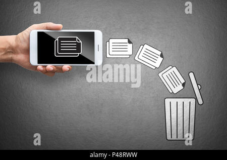 business hand throw data file from mobile to trash bin Stock Photo