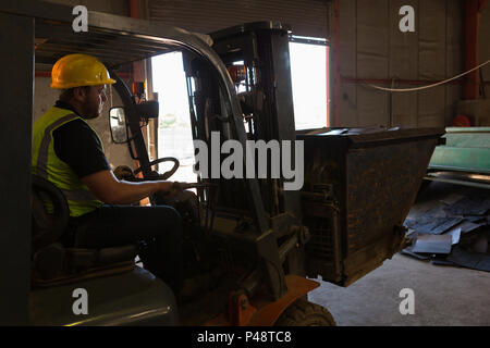 Worker driving a forklift in the junkyard Stock Photo