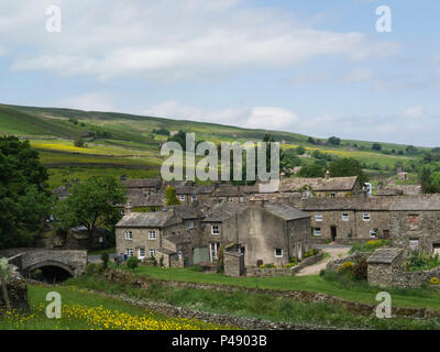 Looking down on small pretty unspoilt village of Thwaite in Swaledale Yorkshire Dales National Park England UK Stock Photo