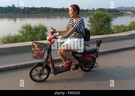 Late on a hot summer afternoon woman cools off along the Yellow River, Taian, Shangdong Province, China Stock Photo