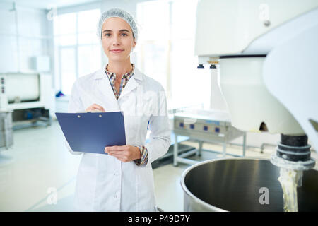 Confectionery factory worker standing with clipboard Stock Photo