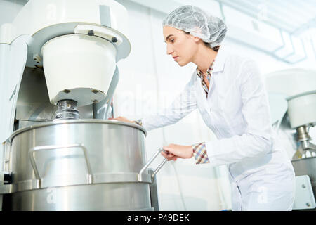 Confectioner using machinery at factory Stock Photo