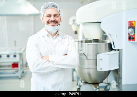 Confectionery factory worker standing and smiling Stock Photo