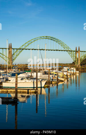 Boats moored in Port of Newport Marina and Yaquina Bay Bridge, Newport, Oregon USA Stock Photo